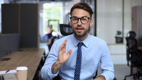 Confident business man looking at camera talking about company strategy and business plan, explaining corporate success 